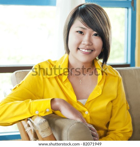 Portrait of a beautiful young woman sitting on sofa.