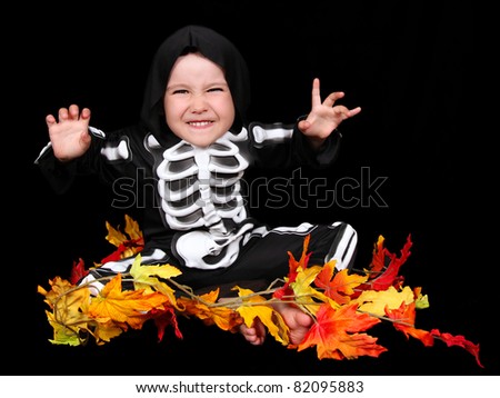 adorable little boy dressed in scary skeleton costume. isolated on black