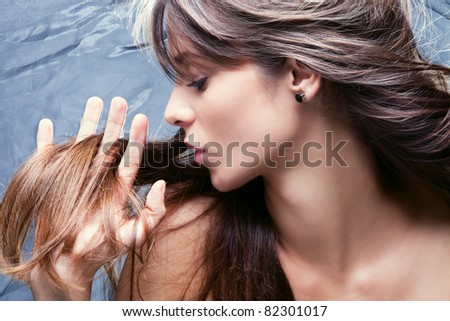 young brunette woman with nourished long  hair, studio shot, profile,