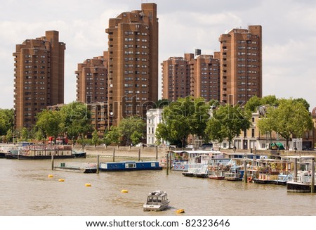Houseboats moored on the River Thames at Chelsea.  The tower blocks of the World's End estate are behind.