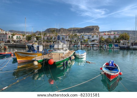 Colorful fishing boats moored in the small marina of Puerto de Mogan on the south coast of Gran Canaria Island, Spain. Royalty-Free Stock Photo #82331581