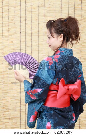 Japanese woman in traditional clothes of Kimono with a japanese fan