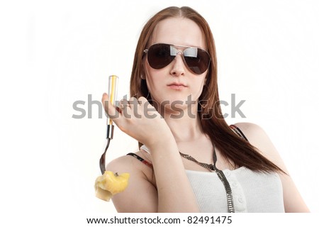 beautiful young girl standing and eating an orange, isolated over white