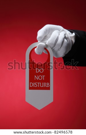  close up of the hotel staff holding a door sign do not disturb