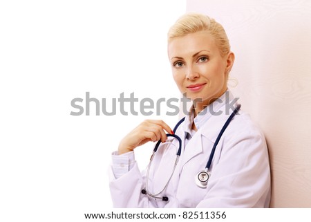 A female doctor standing near the wall, isolated on white background