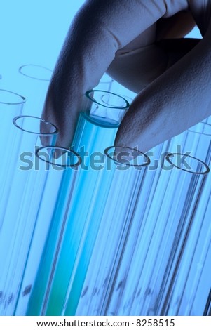 A hand holding a test tube in plain background.