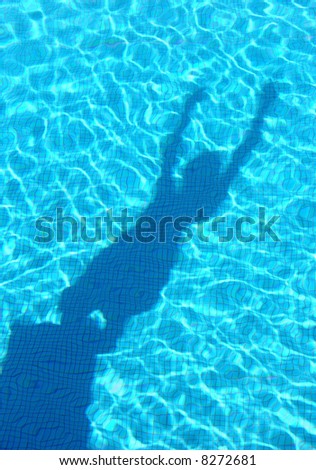 Shadow of young boy diving in the swimming pool