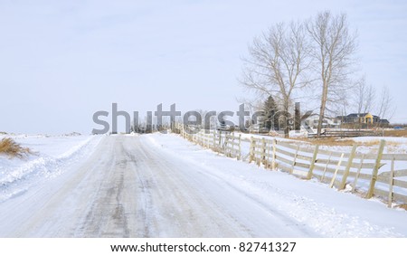 White picket fence along a freezing, snow covered, country road