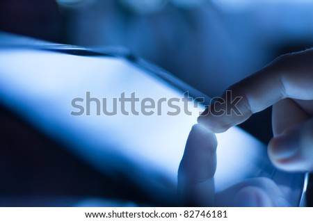 closeup of finger touching screen  on tablet-pc with shallow depth of field blue toned Royalty-Free Stock Photo #82746181