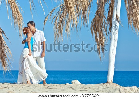 romantic couple wearing hats on the beach