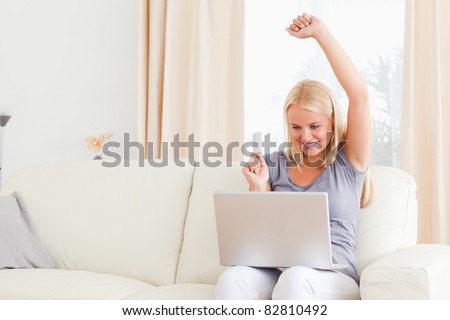 Smiling blonde woman buying online in her living room