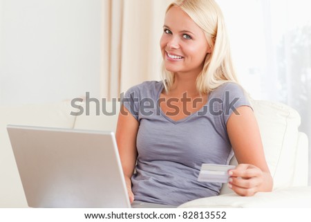 Delighted woman buying online in her living room