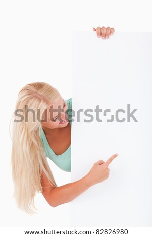 Blond-haired woman pointing at a whiteboard in a studio