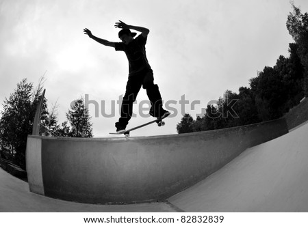 perfect silhouette of a skateboarder doing a  trick at the skate park.