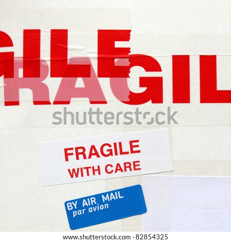 Fragile warning sign label tag on a cardboard box packet parcel for mail post shipping