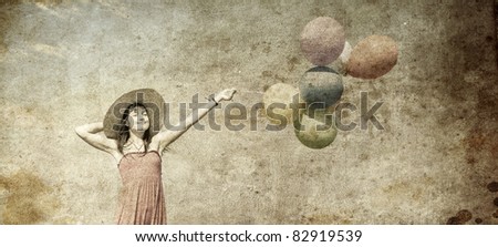 Brunette girl with colour balloons at blue sky background. Photo in old image style.