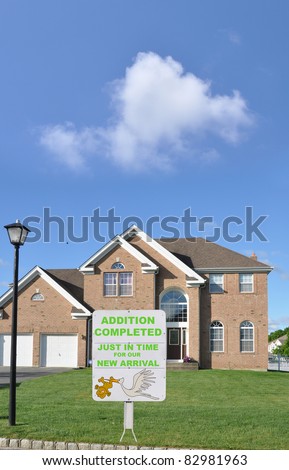 Birth Announcement on Front Yard Lawn of Brick Suburban McMansion Home in USA