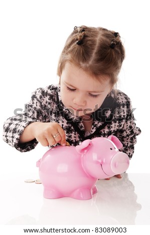 Adorable little baby girl playing with money pig