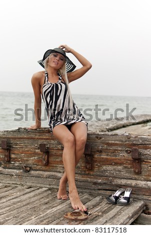 girl in a hat sitting on a broken ship at sea