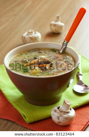 mushroom soup in a clay pot over wood table