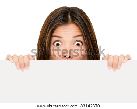 Banner sign woman peeking over edge of blank empty paper billboard with copy space for text. Beautiful Asian Caucasian woman looking surprised and scared - funny. Isolated on white background.