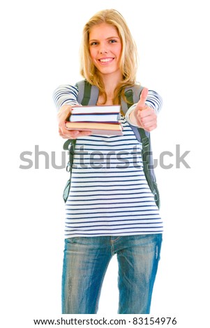 Cheerful pretty girl with backpack and books showing thumbs up isolated on white