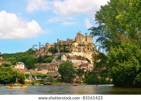 Beautiful landscape with tourists kayaking on river Dordogne and Château de Beynac in the background as seen in Beynac-et-Cazenac, Southern France