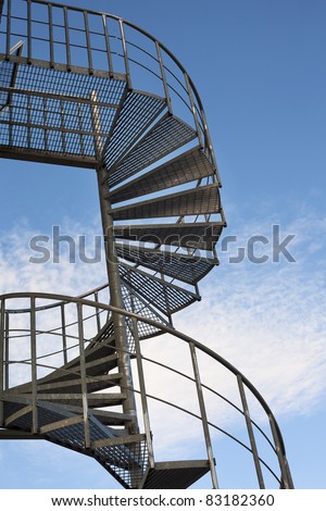 Industrial spiral stairway on sky background