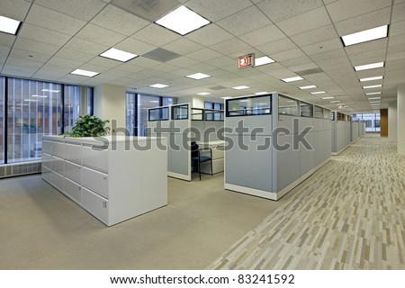 Office area with cubicles in high rise building Royalty-Free Stock Photo #83241592