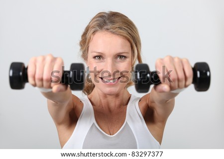Woman working out with dumbbells Royalty-Free Stock Photo #83297377