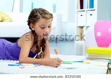 Portrait of lovely girl drawing with colorful pencils
