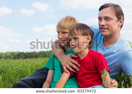 happy dad with his sons at field