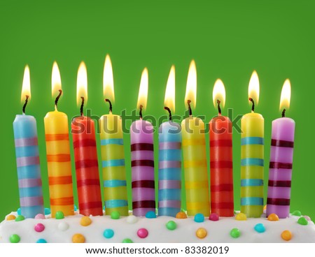 Ten colorful candles on green background