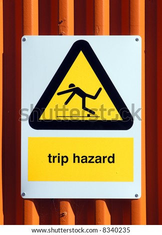 Trip Hazard sign on an orange tin wall
