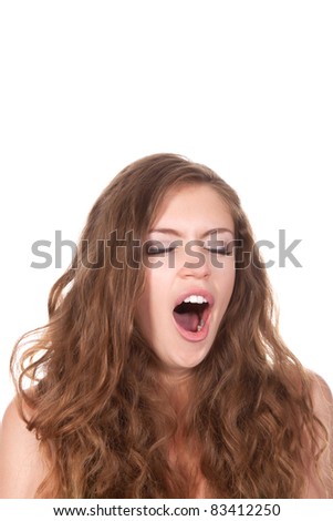 portrait of attractive yawn teenage girl with brown long hair, isolated over white background concept of beautiful young pretty woman with mouth wide open