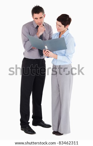 Office workers looking at a binder against a white background