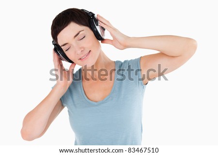 Close up of a woman enjoying some music against a white background