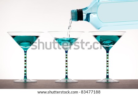 liquor being poured into martini glasses