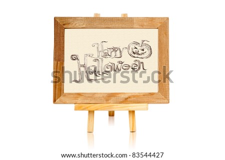 Hand writing "Halloween" on cream paper with wooden framing and stand