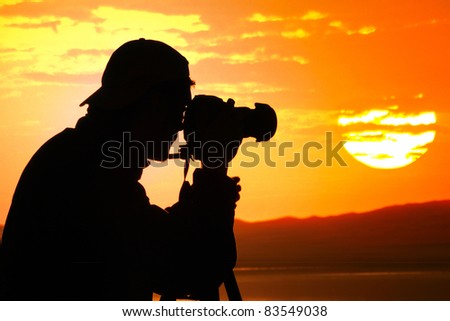 Photographer silhouette shooting sea outdoors at sunset background