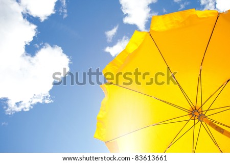 yellow umbrella on blue sky with clouds Royalty-Free Stock Photo #83613661