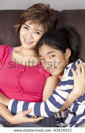 mom and daughter, mother in pink dress hug her daughter happy.