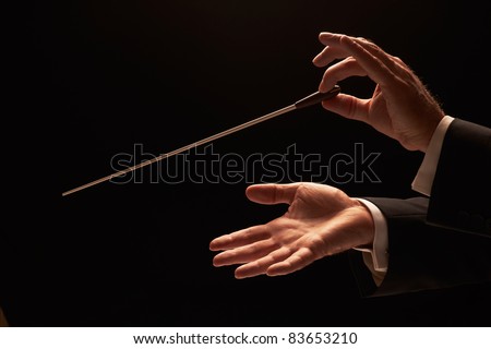 Conductor conducting an orchestra isolated on black background Royalty-Free Stock Photo #83653210