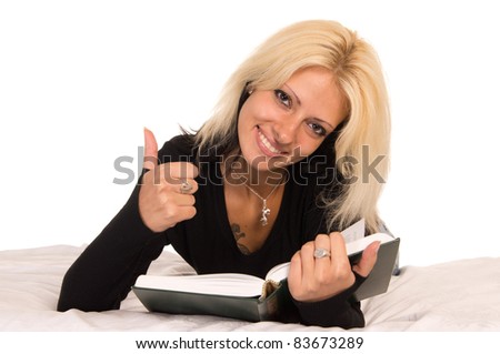 cute girl lying with a book on bed