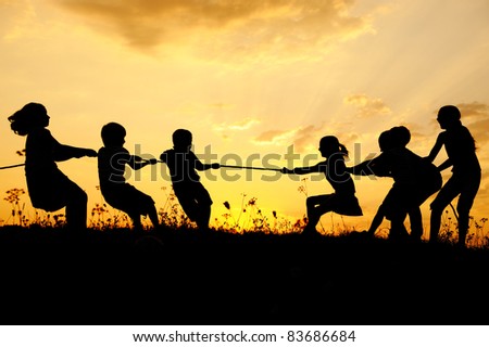 Children pulling rope, tug war, sunset, group, copy space Royalty-Free Stock Photo #83686684