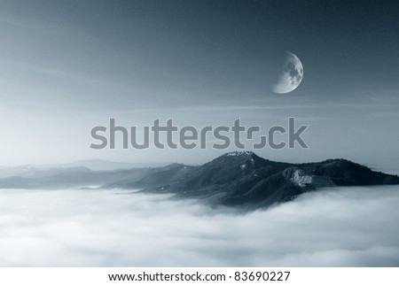 starry sky with moon over the foggy valley