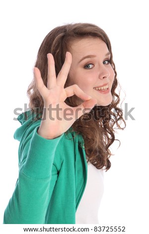 Okay hand sign for success by happy pretty teenager school girl with long brown hair. Girl has blue eyes and a big beautiful smile.