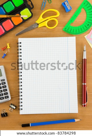 school accessories and checked notebook on wood texture