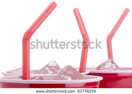 Red straws in red cups with water and ice.