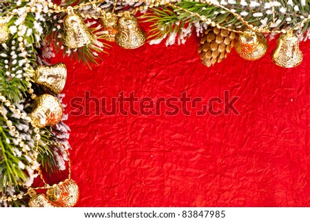 Christmas frame from branch and bells on red paper background